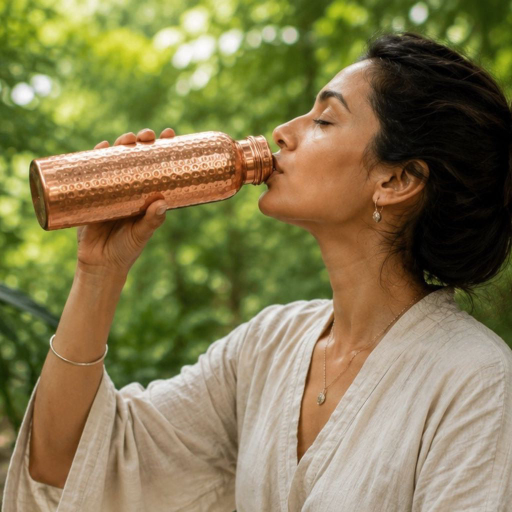 Vrouw drinkt uit koperen drinkfles